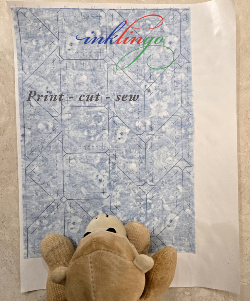 blue fabric printed with diamonds, triangles, squares on letter size freezer paper